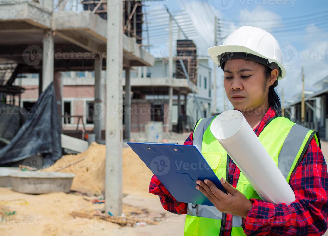 Engineers holding blueprint project working outdoors building side with blueprints on a worksite, Engineering and architecture concept, Engineer working at site of a large building project. photo