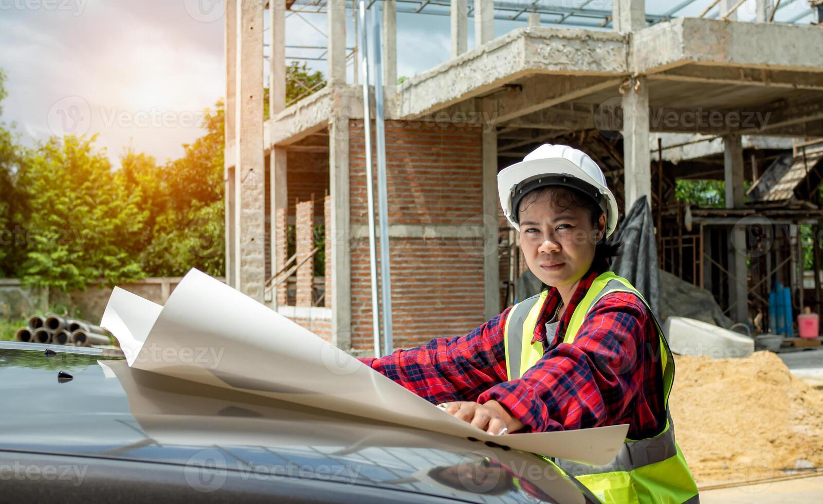 Engineers checking blueprint and planning project working outdoors building side on a worksite, Engineering and architecture concept, Engineer working at site of a large building project. photo