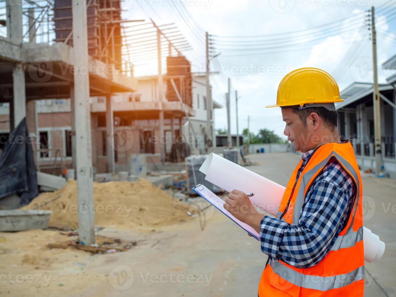 Engineers holding blueprint project working outdoors building side with blueprints on a worksite, Engineering and architecture concept, Engineer working at site of a large building project. photo