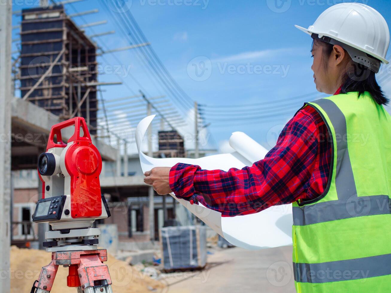 Engineers holding blueprint project working outdoors building side with blueprints on a worksite, Engineering and architecture concept, Engineer working at site of a large building project. photo