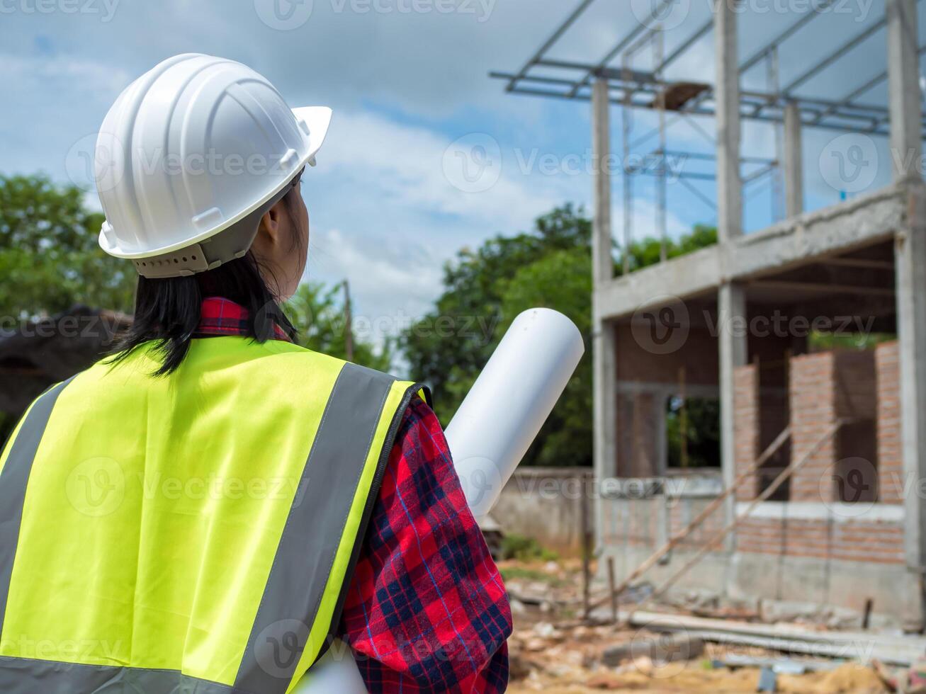 Engineers holding blueprint project working outdoors building side with blueprints on a worksite, Engineering and architecture concept, Engineer working at site of a large building project. photo