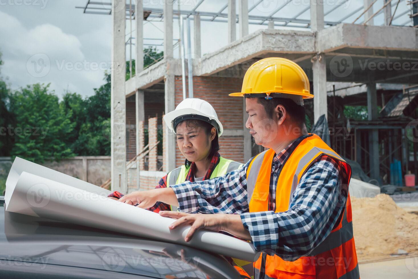 Team engineers checking blueprint and planning project working outdoors building side on a worksite, Engineering and architecture concept, Engineers having meeting regarding new construction phase. photo