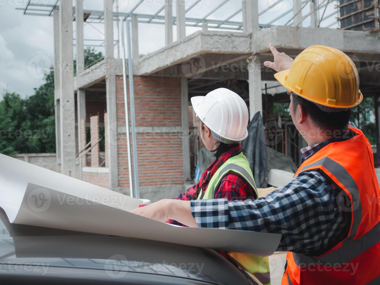 Team engineers checking blueprint and planning project working outdoors building side on a worksite, Engineering and architecture concept, Engineers having meeting regarding new construction phase. photo