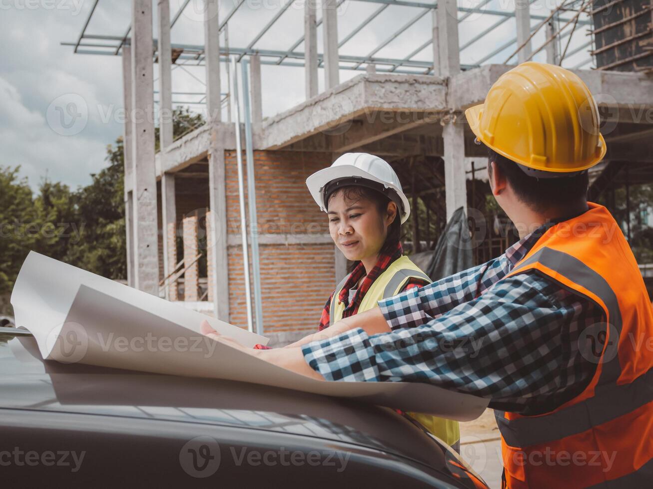 Team engineers checking blueprint and planning project working outdoors building side on a worksite, Engineering and architecture concept, Engineers having meeting regarding new construction phase. photo