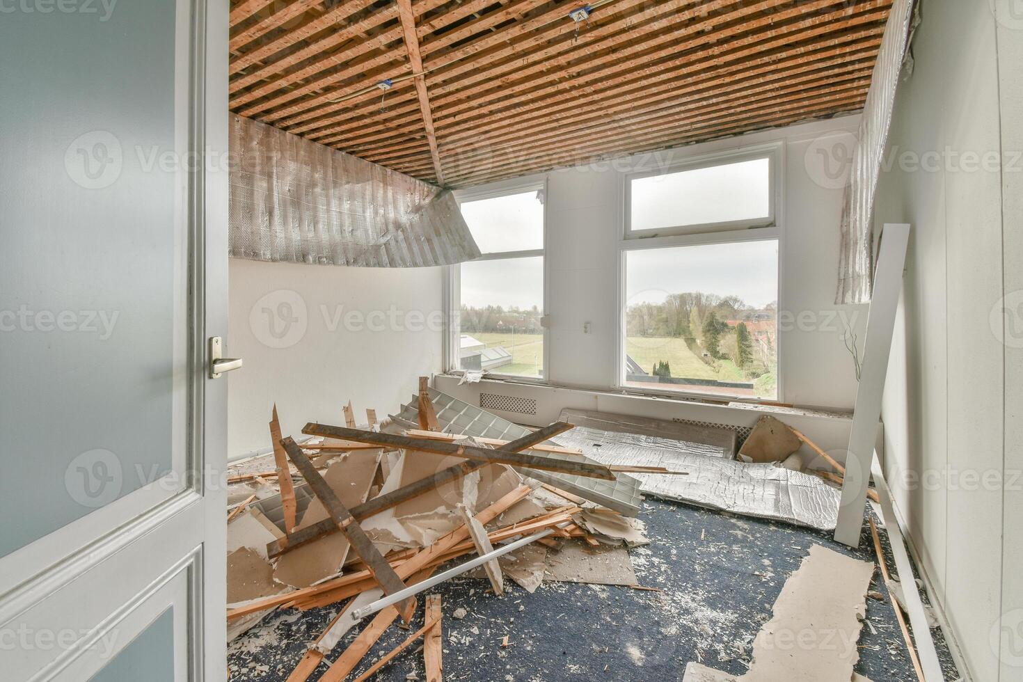 A room with a broken window and a pile of debris photo