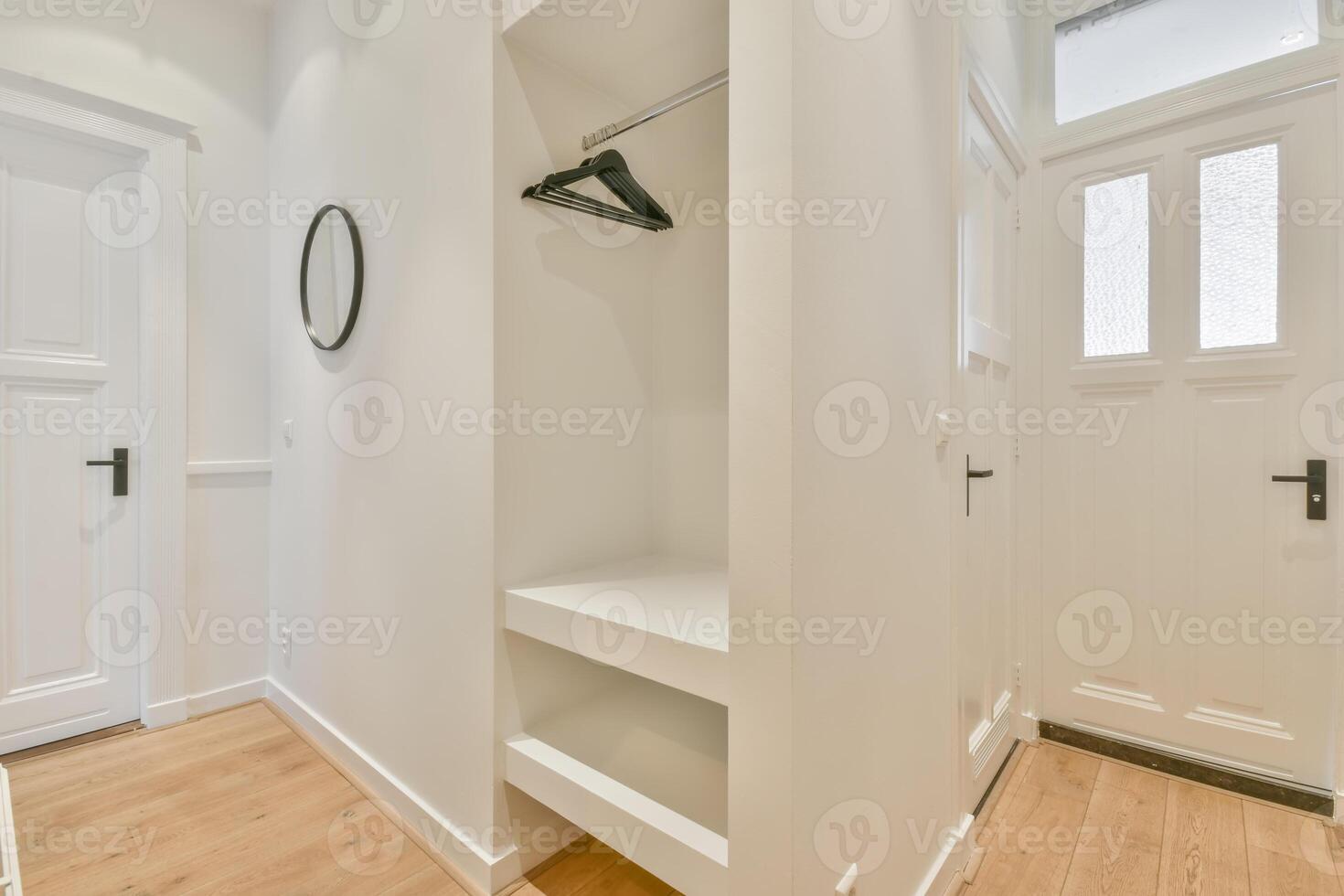A white hallway with a closet and a door photo