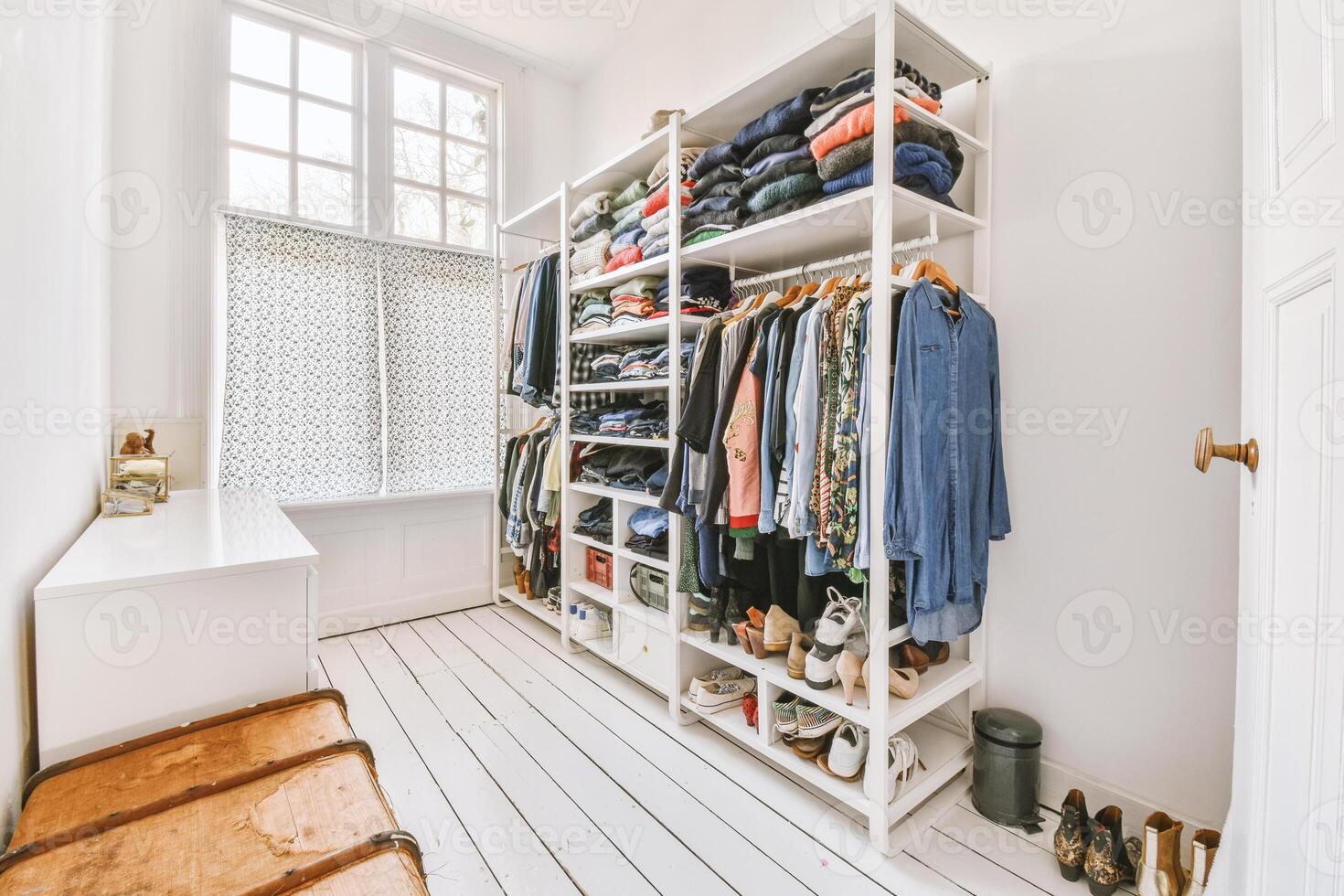 A white closet with clothes and shoes photo