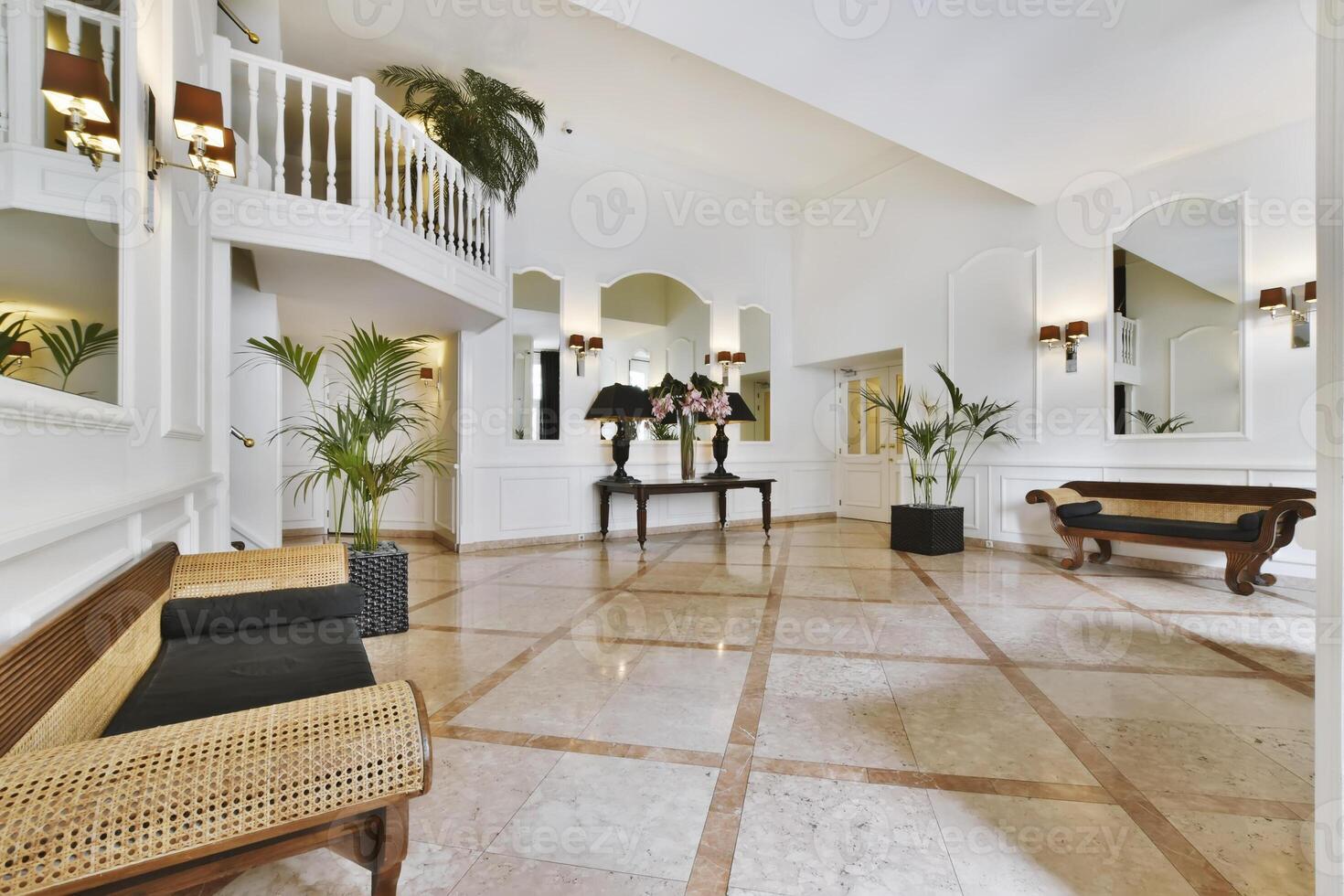 A white hallway with a large mirror and a wooden bench photo