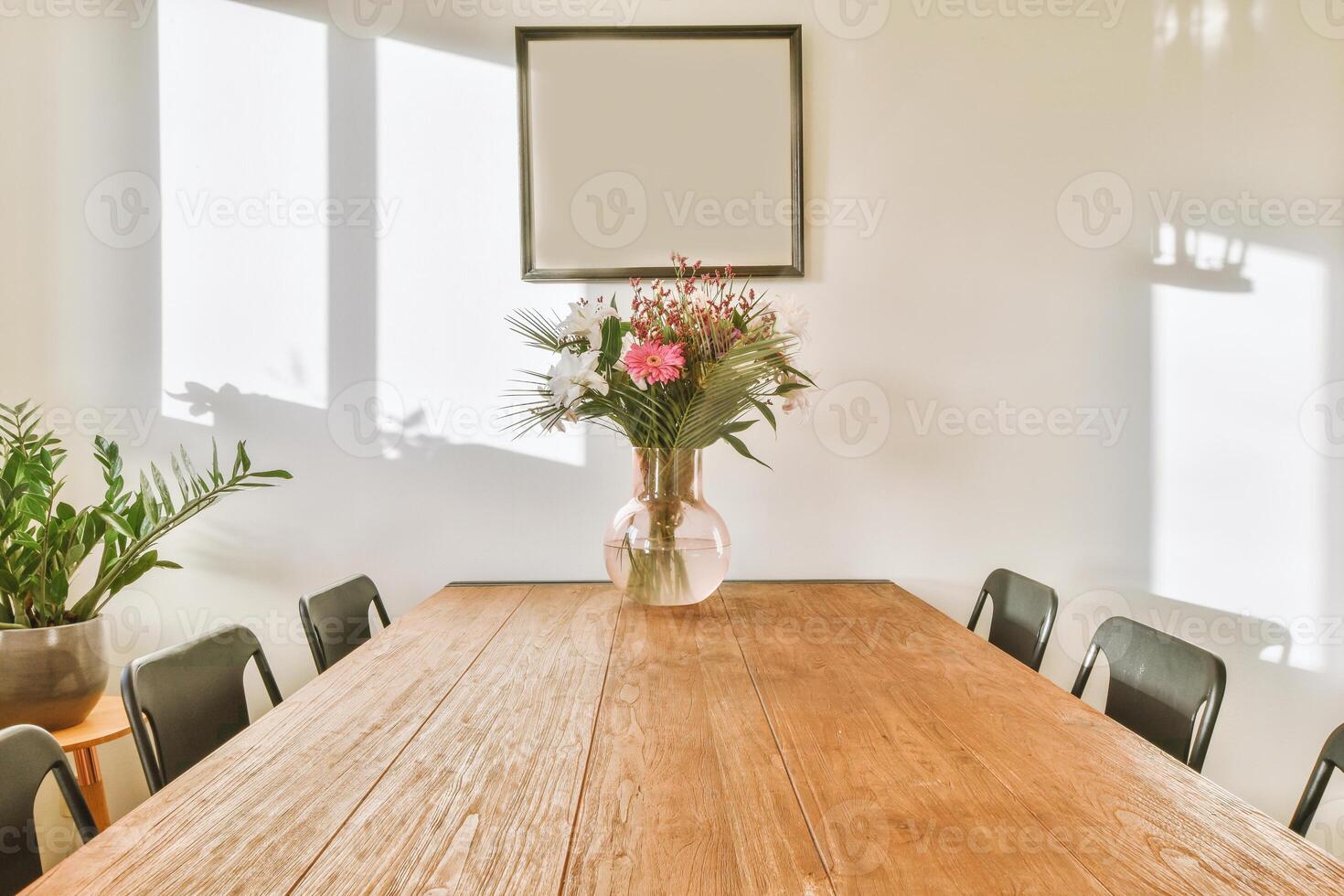 A wooden table with chairs and a vase of flowers photo