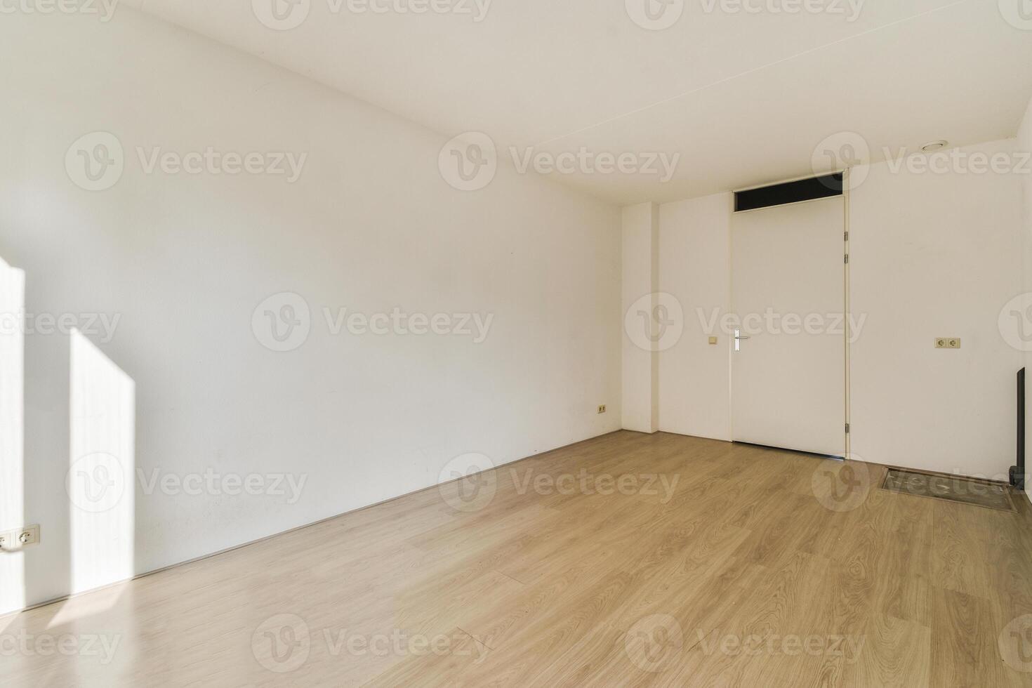 An empty room with wooden floors and white walls photo
