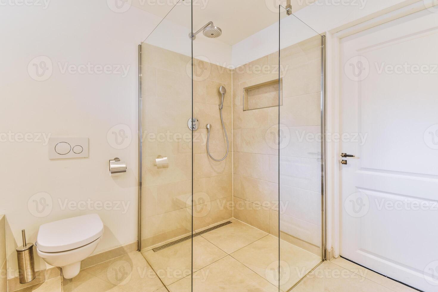 A bathroom with a glass shower door and toilet photo