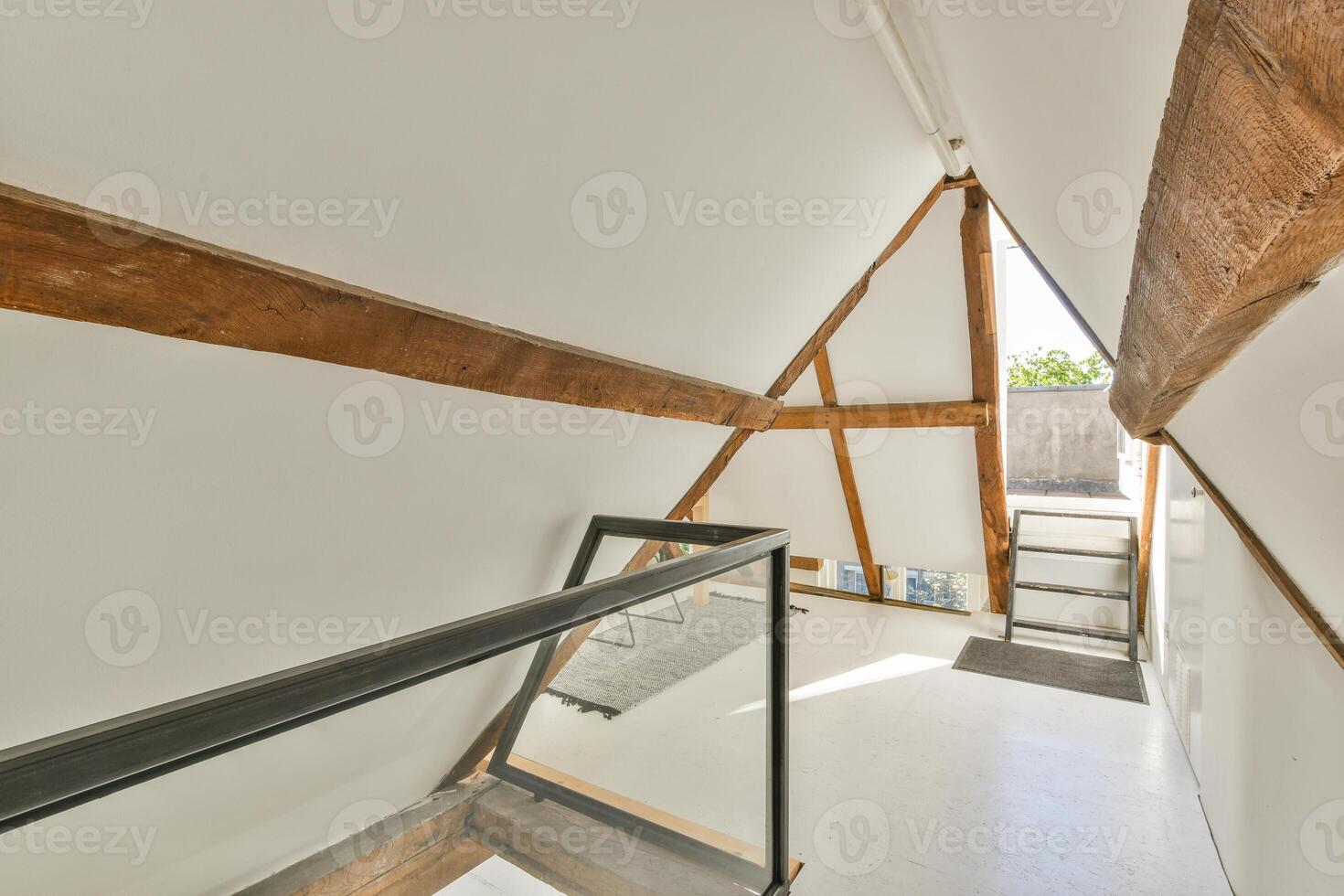 A triangle shaped house with a staircase and wooden beams photo