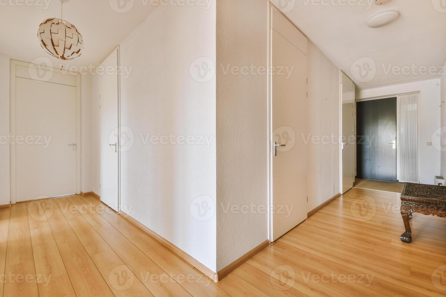 A hallway with wooden floors and white walls photo