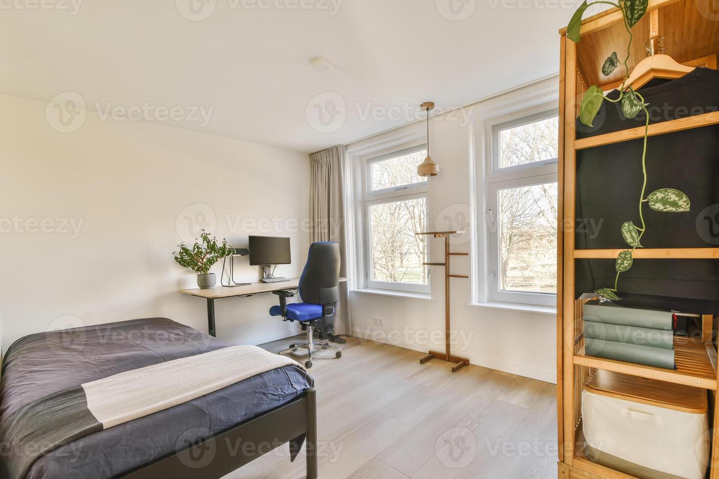 A bedroom with a bed, desk and window photo