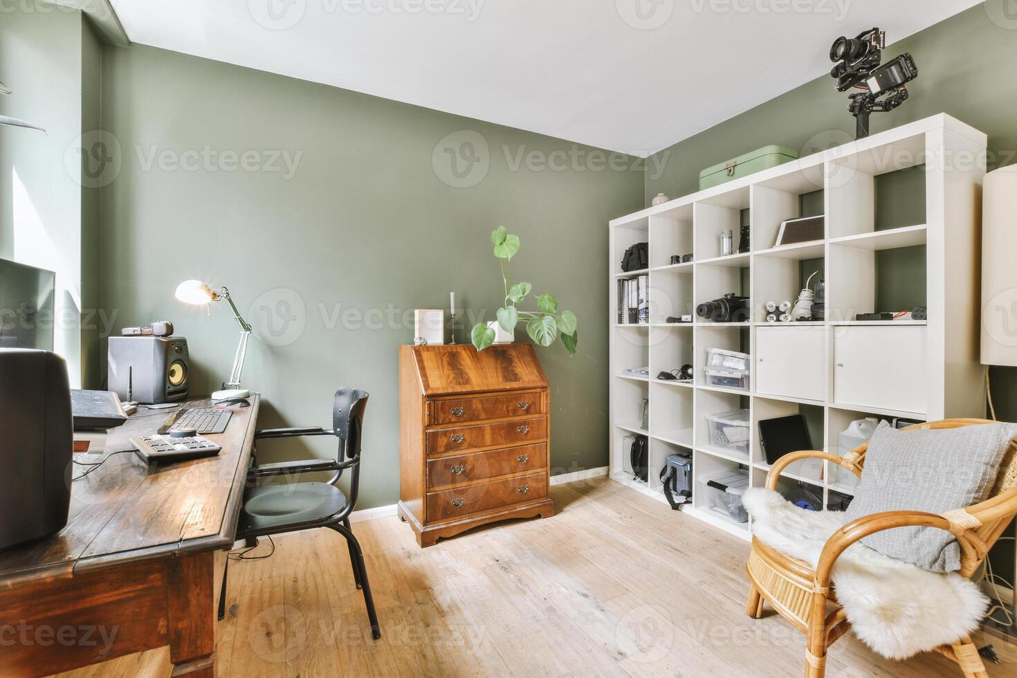 A home office with green walls and wooden floors photo