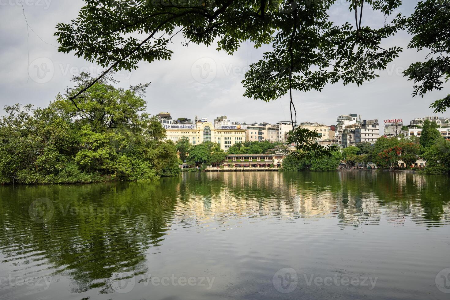 Hanoi, Vietnam - 26 June 2024 Hoan Kiem lake or Sword lake, Ho Guom in Hanoi, Vietnam with Turtle Tower, on clear day with blue sky and white clouds photo