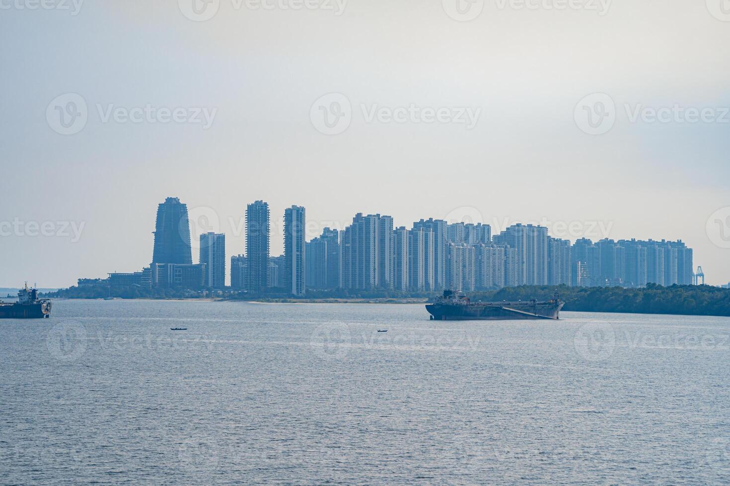 Tuas Second Link Bridge connecting Singapore and Johor, Malaysia. Buildings at Forest City and Singapore's port. View from the Straits of Johor. photo