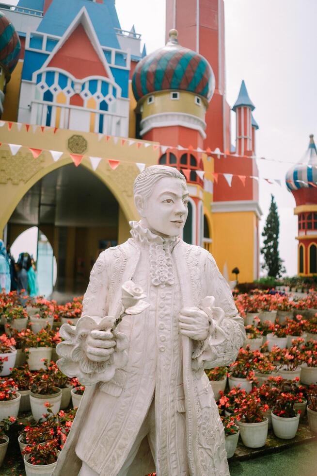 Bogor, September 2 2024. A statue of a man with a Disneyland-style castle in the background photo