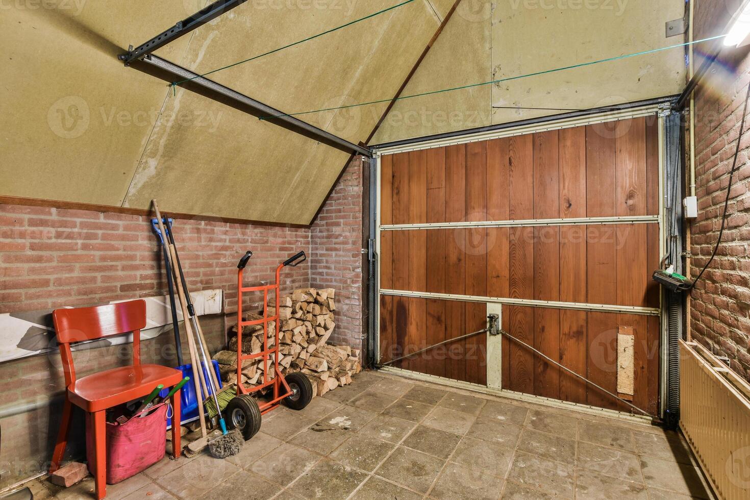 A garage with a door and a red chair photo