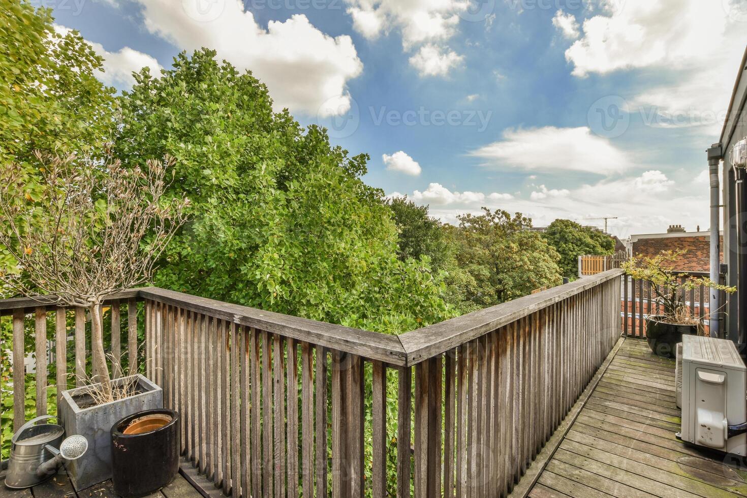 A balcony with wooden decking and trees photo