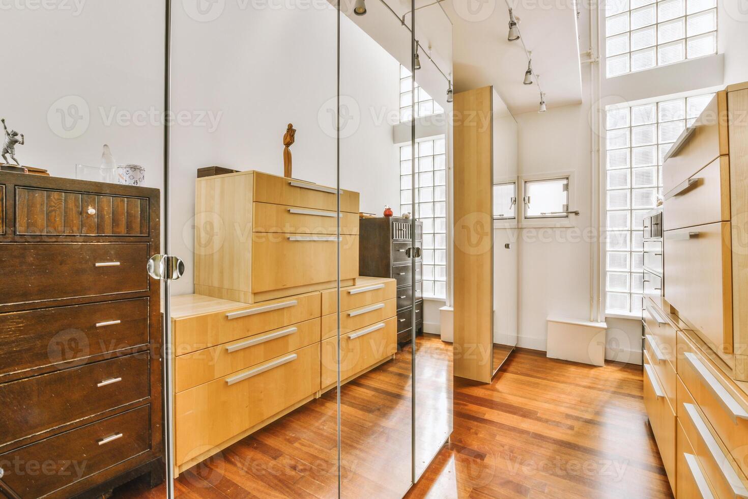 A bedroom with a large mirror and wooden flooring photo