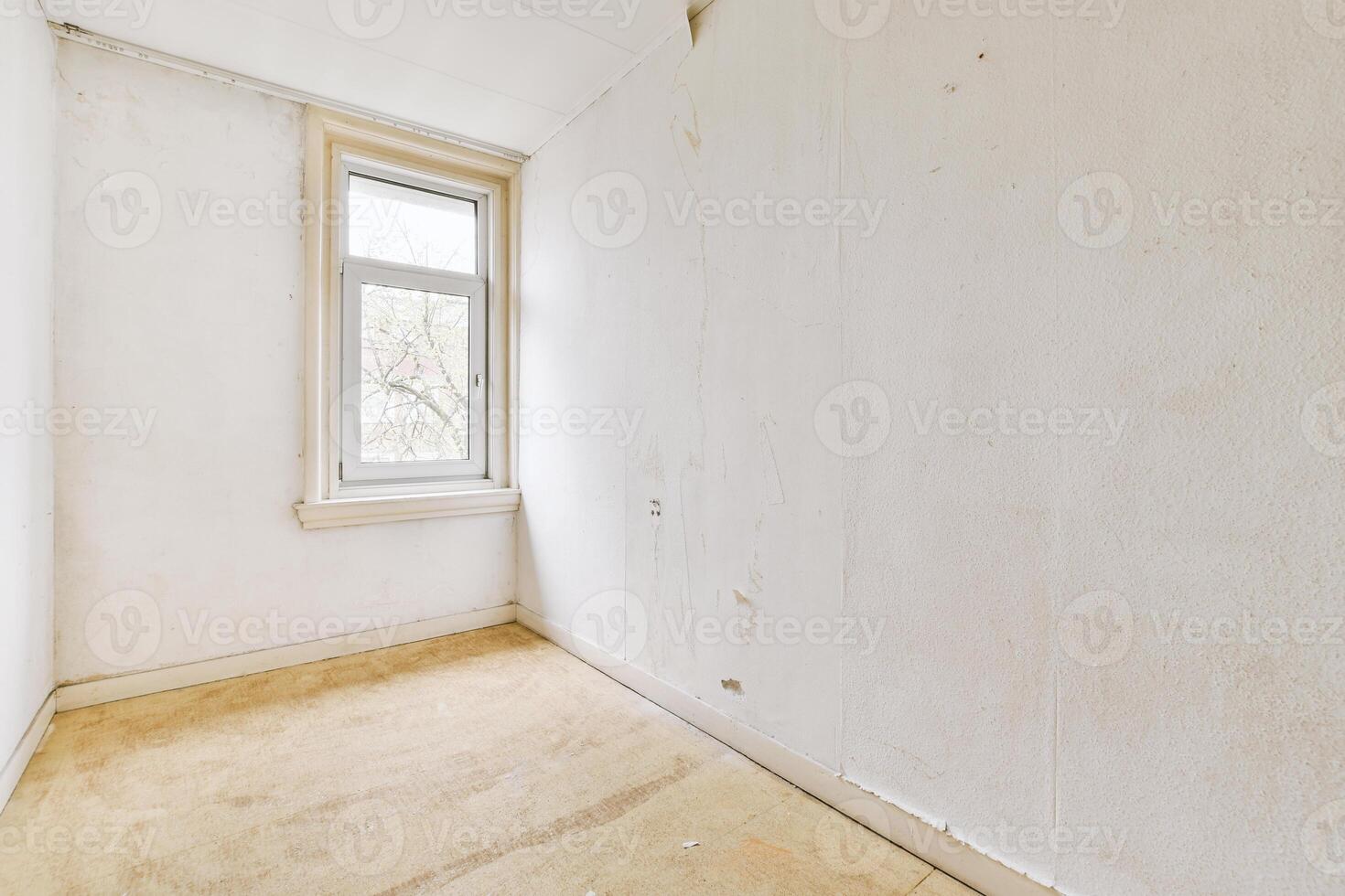 An empty room with a window and a wooden floor photo