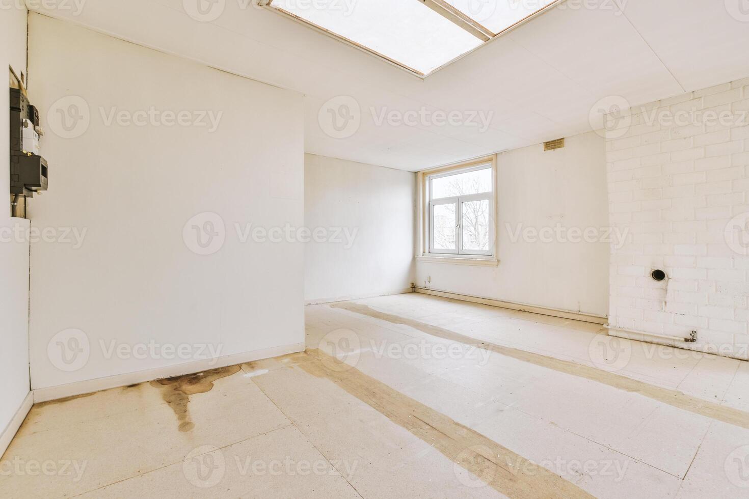 A white room with a skylight and a window photo