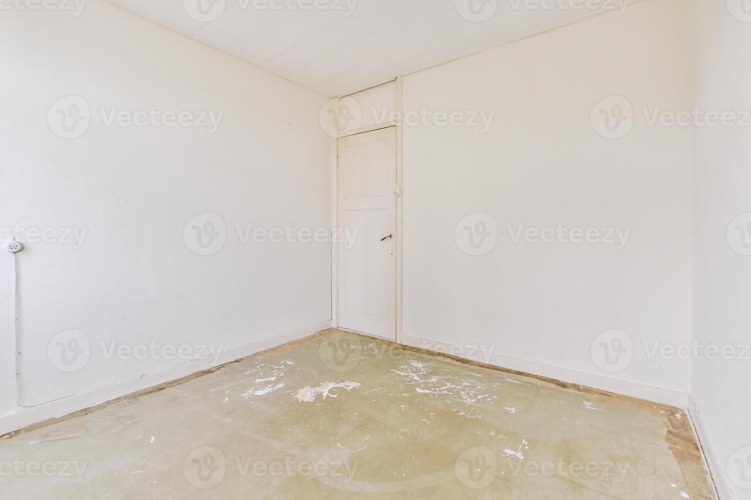 An empty room with a white door and a floor photo