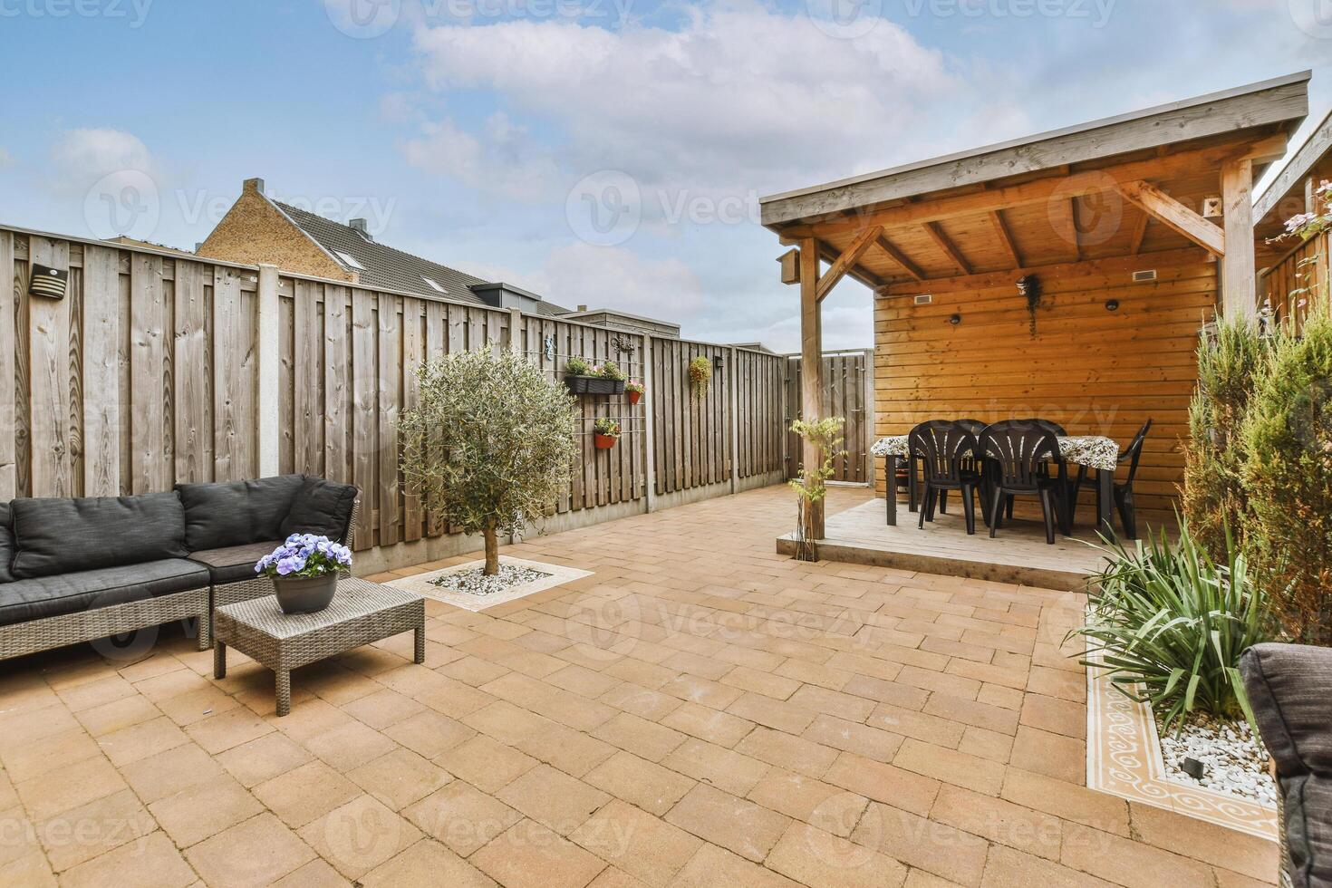 A patio with a wooden fence and a couch photo