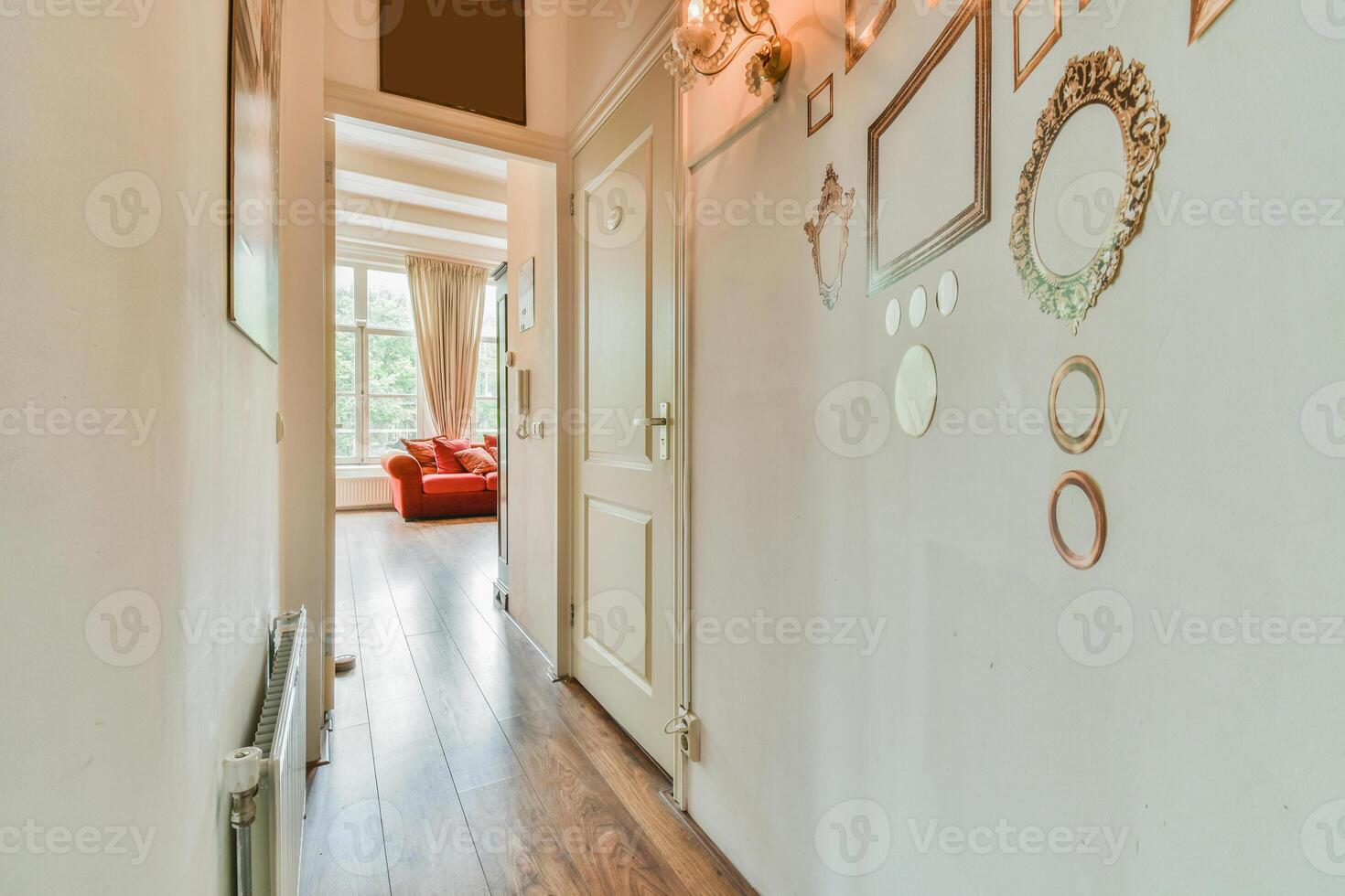 A hallway with a red couch and a wall of pictures photo