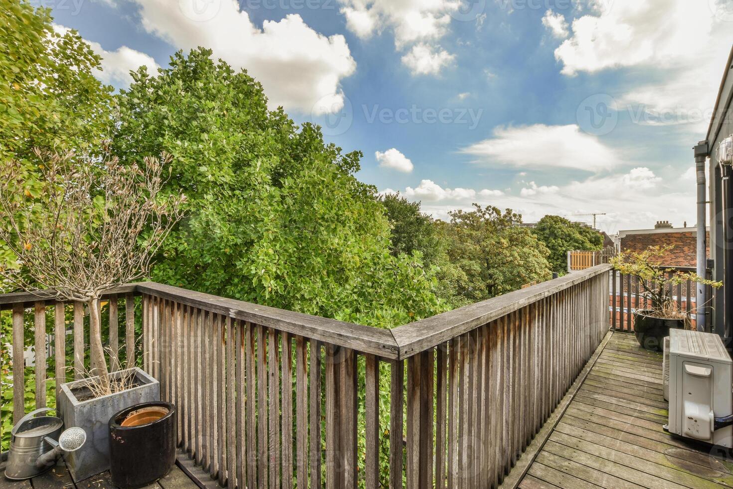 A balcony with wooden decking and trees photo
