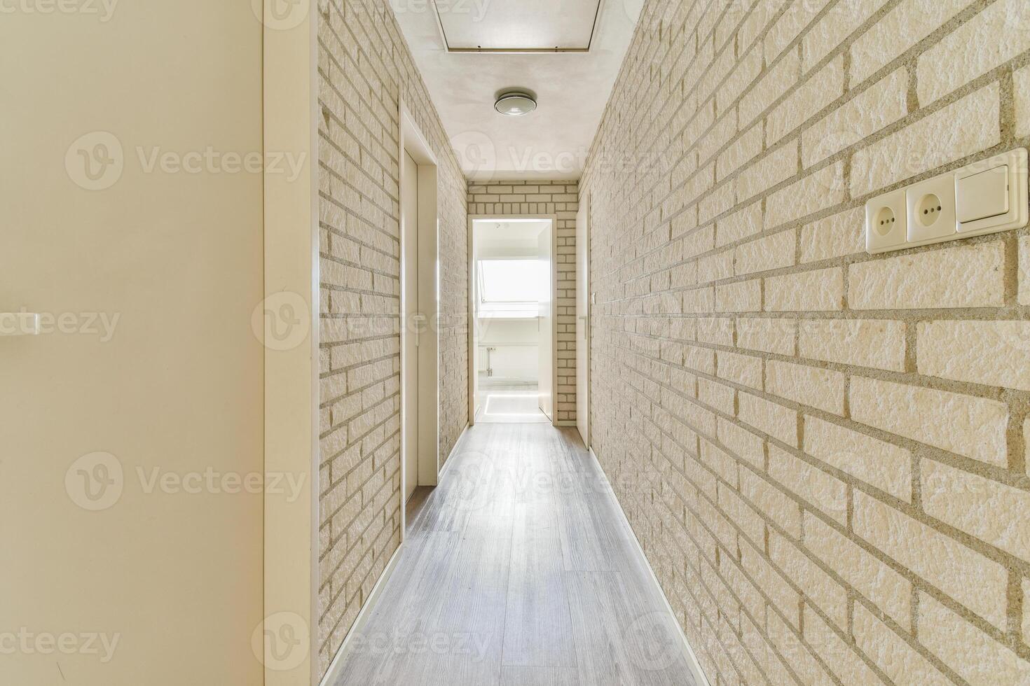 A hallway with a brick wall and wooden floor photo