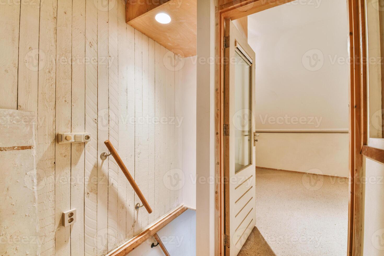 A hallway with a wooden door and a wooden staircase photo