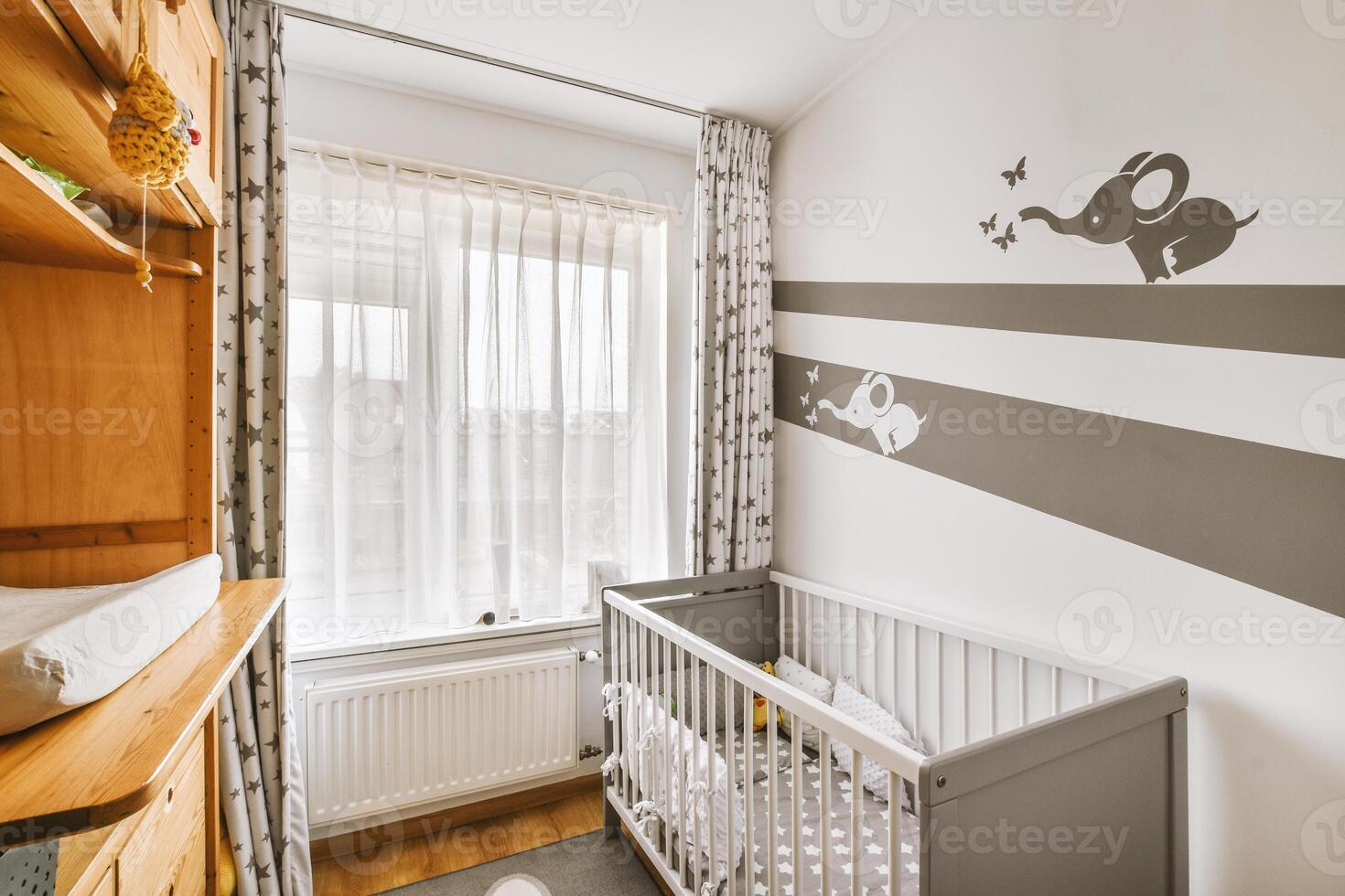 A baby's room with a crib, a dresser and a window photo