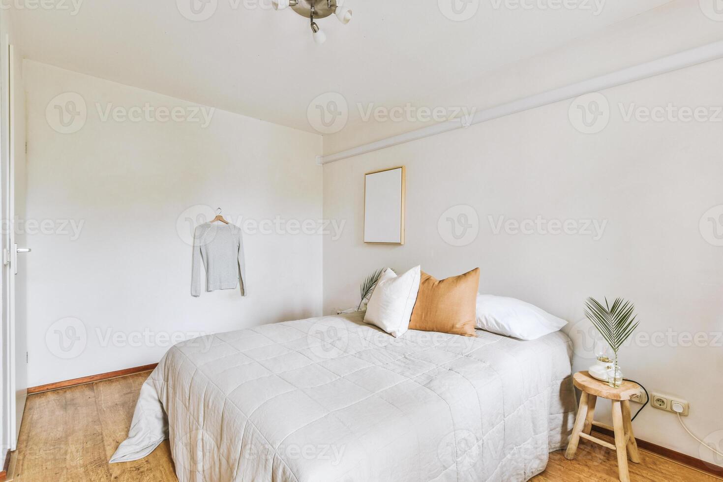 A bedroom with a bed, a chair and a lamp photo