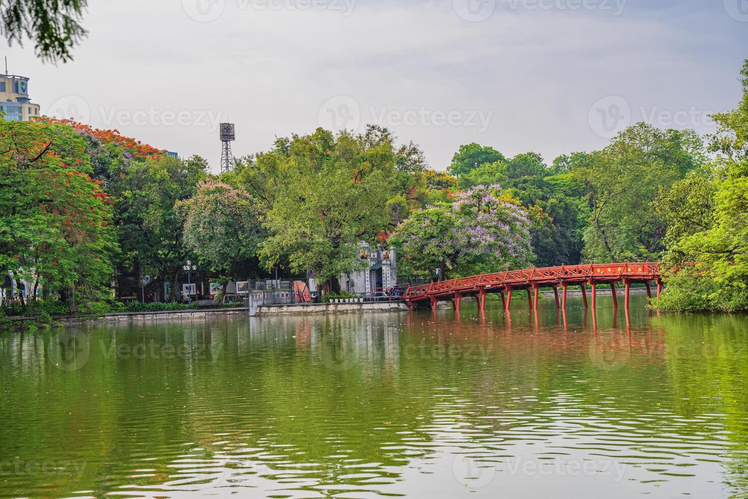 Hanoi, Vietnam - 26 June 2024 Red The Huc Bridge and Ngoc Son Temple in the center of Hoan Kiem Lake, Hanoi, Vietnam. Famous destination of Vietnam photo