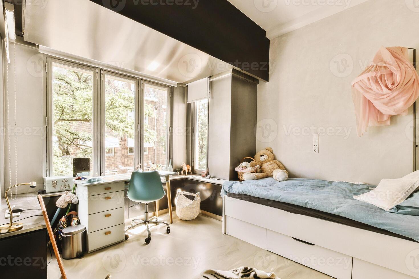 A bedroom with a bed, desk and a window photo