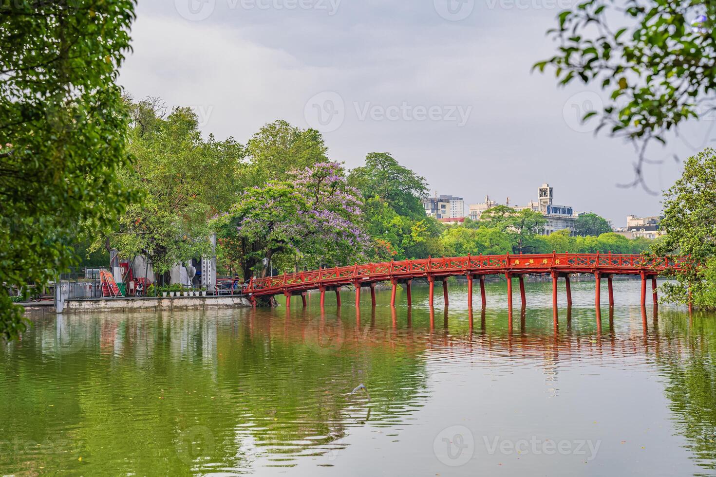 Hanoi, Vietnam - 26 June 2024 Red The Huc Bridge and Ngoc Son Temple in the center of Hoan Kiem Lake, Hanoi, Vietnam. Famous destination of Vietnam photo