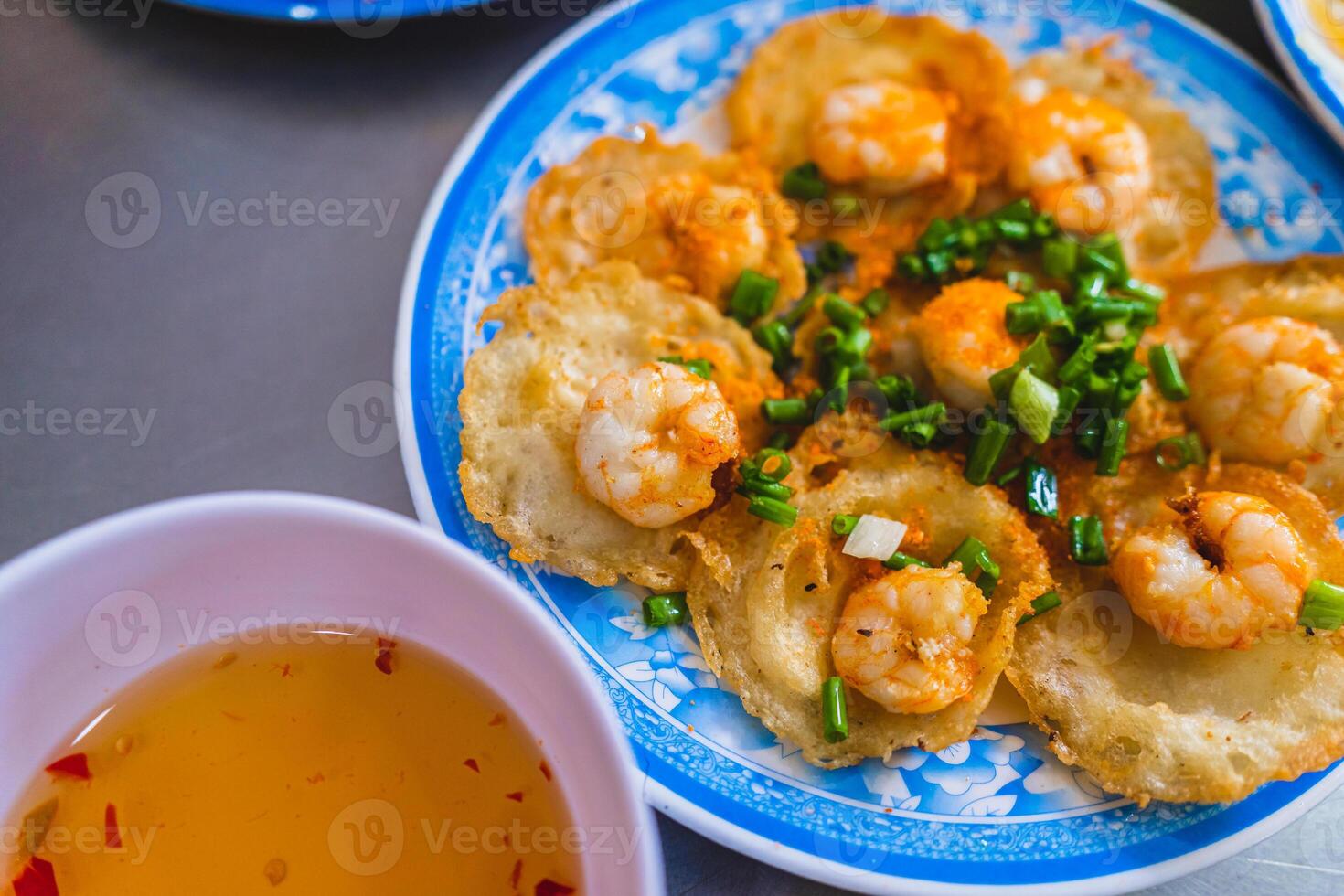 Vietnamese tiny shrimp pancake- Banh Khot Vung Tau. Vietnamese local cuisine. Served with vegetables. Selective focus photo