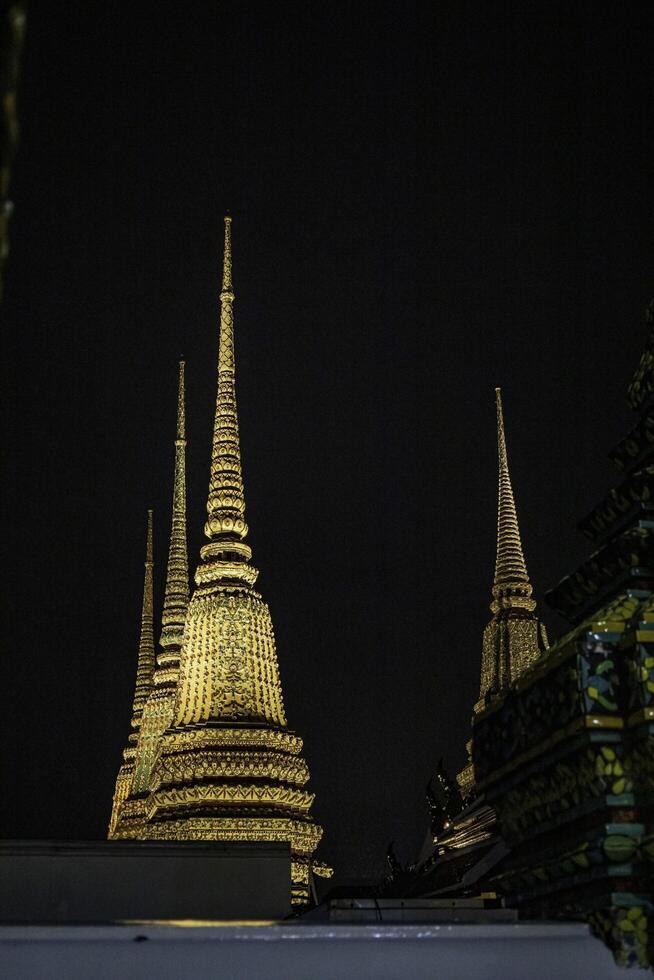 Wat Pho's pagoda-style roof and rich cultural details at night, Bangkok, Thailand. photo