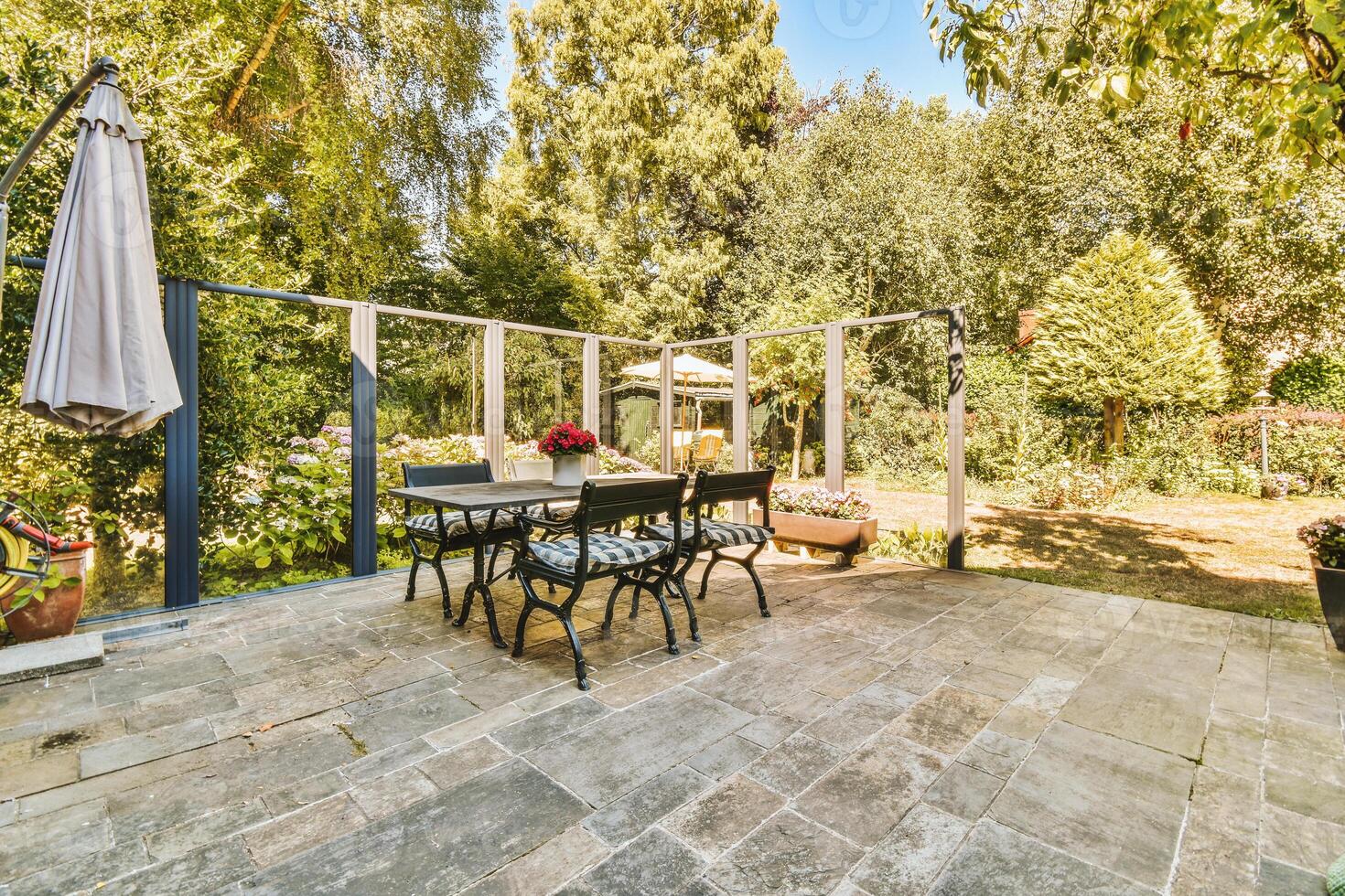 A patio with a table and chairs and a large umbrella photo