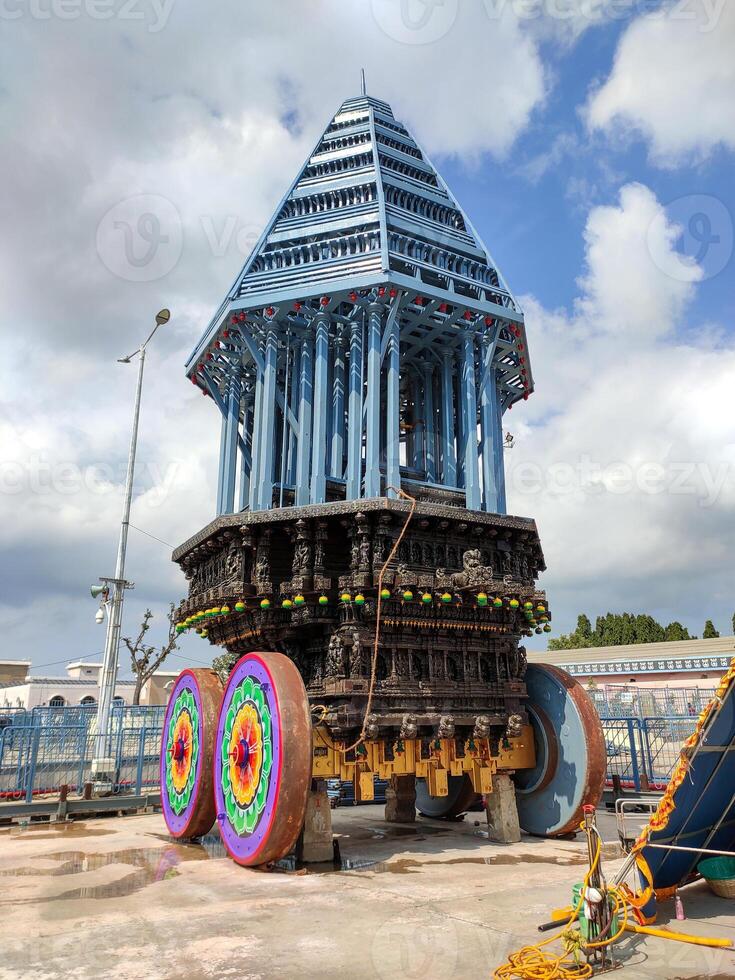 A temple chariot, also called a ratha or ther, is a large, intricately decorated wooden vehicle used in Hindu temple festivals. It plays a key role in the Brahmotsavam festival at Venkateswara Temple photo