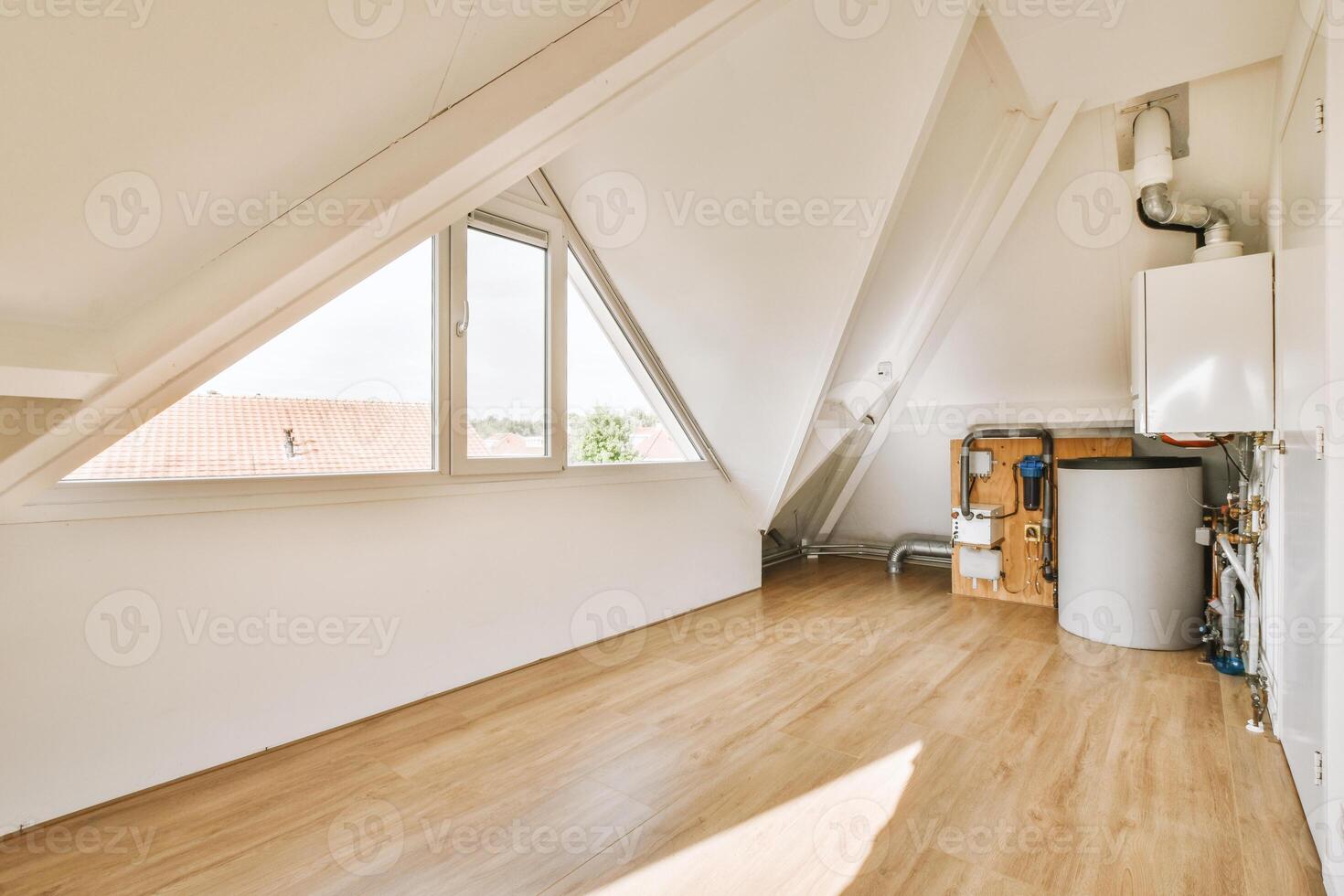 An attic with a window and a water heater photo