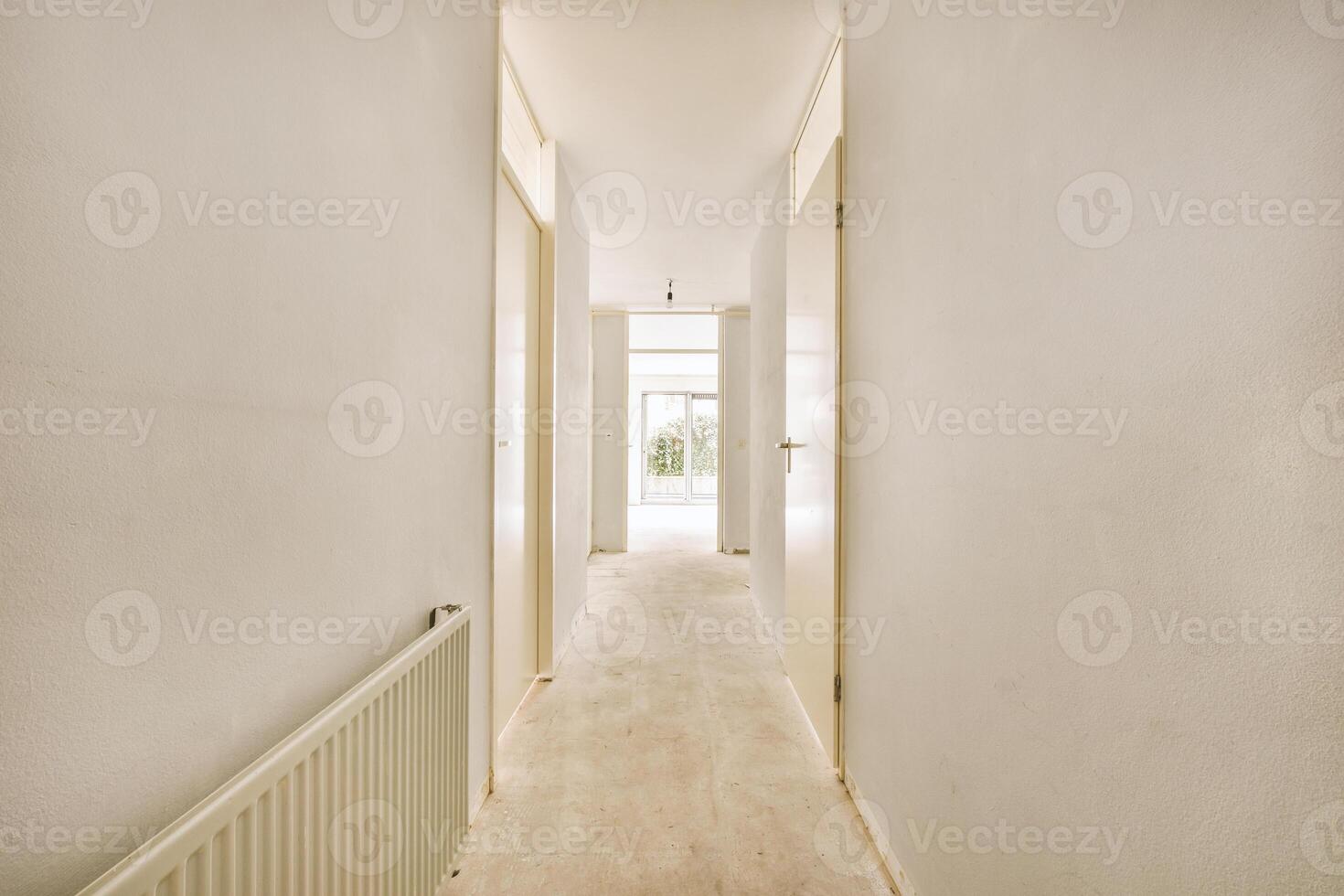 A hallway with a white wall and a radiator photo