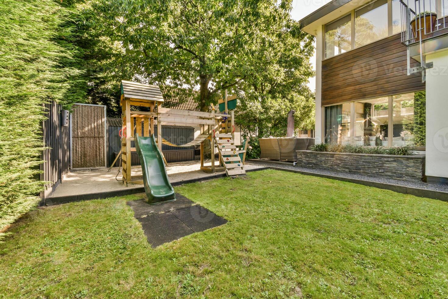 A backyard with a swing set and a tree photo