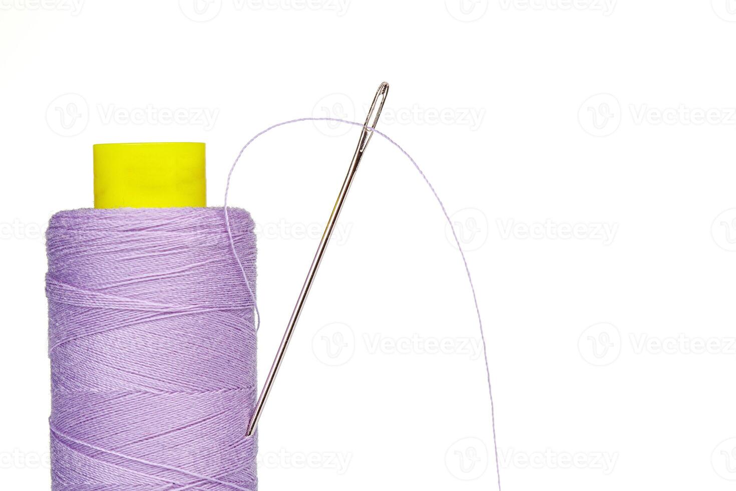 Macro skein of thread purple colors with a needle on a white background photo