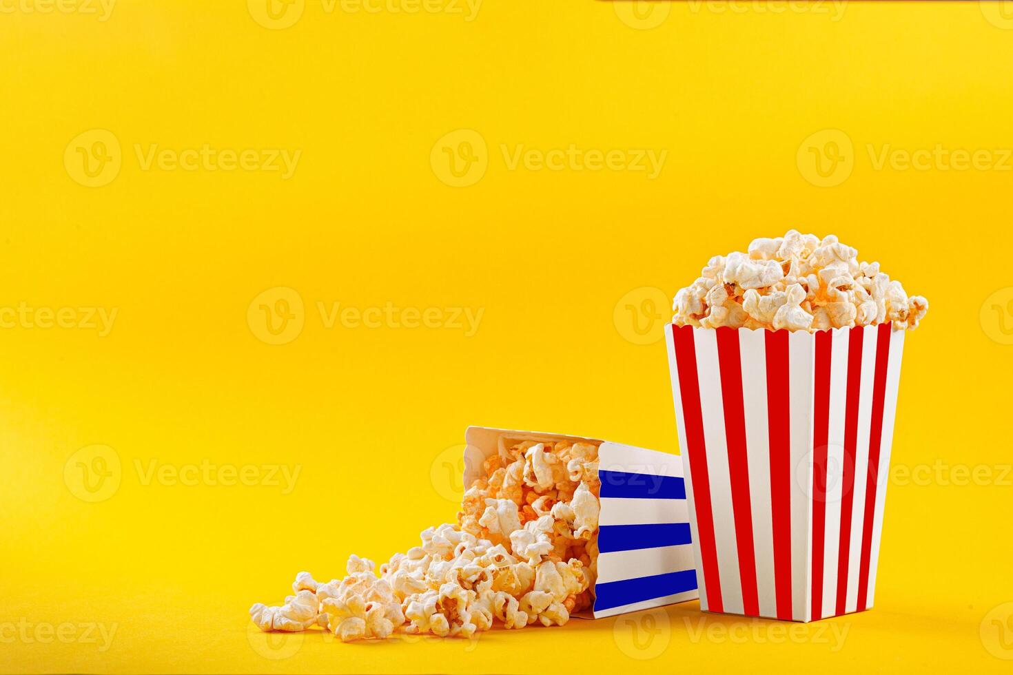 Glass with popcorn on a yellow background photo