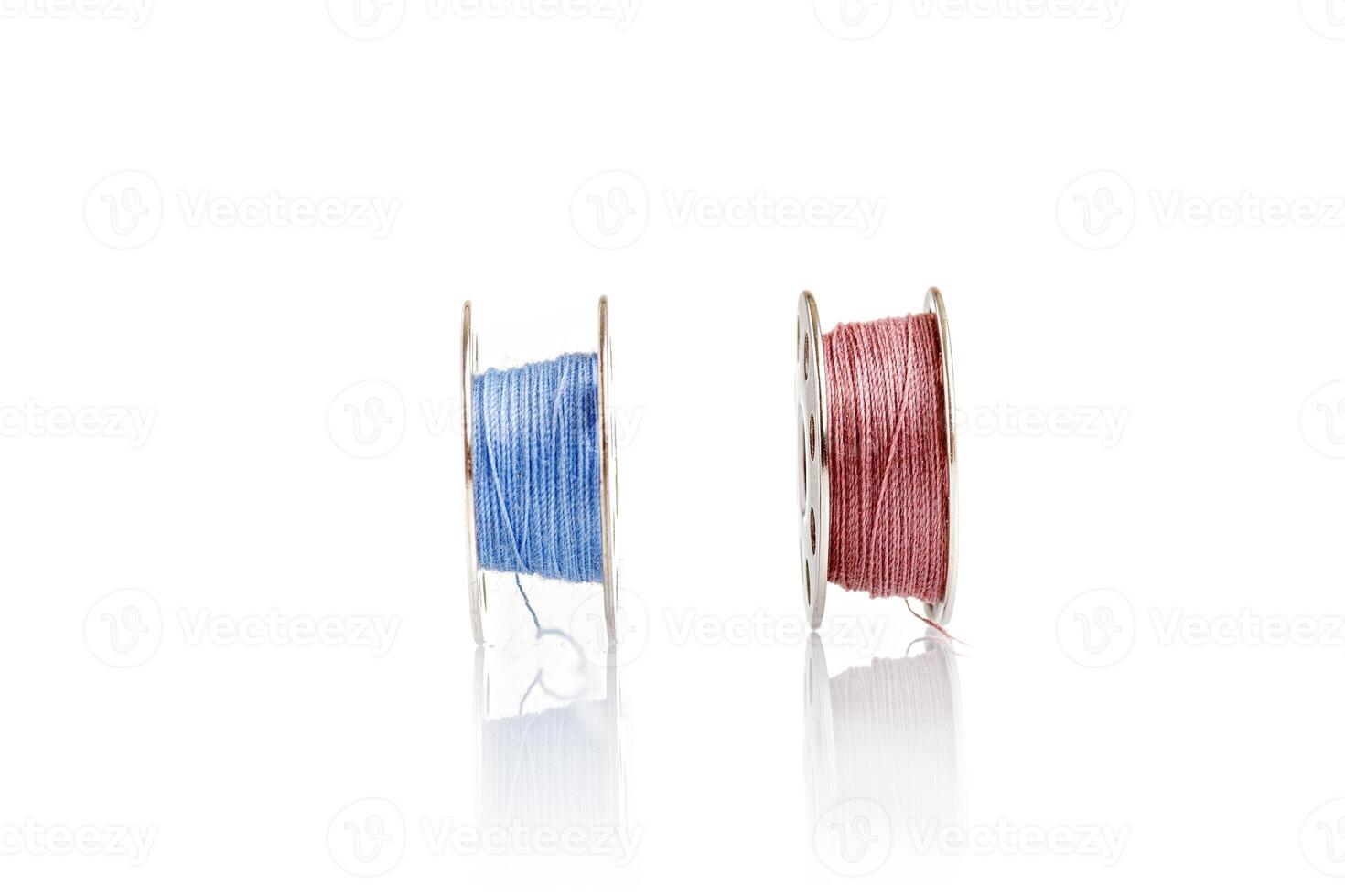 spools of blue and pink thread on a white background photo