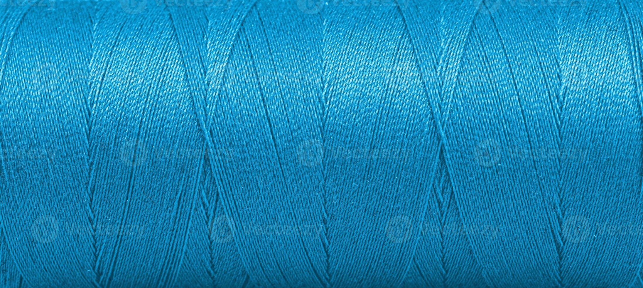 Texture of threads in a spool of blue color on a white background photo