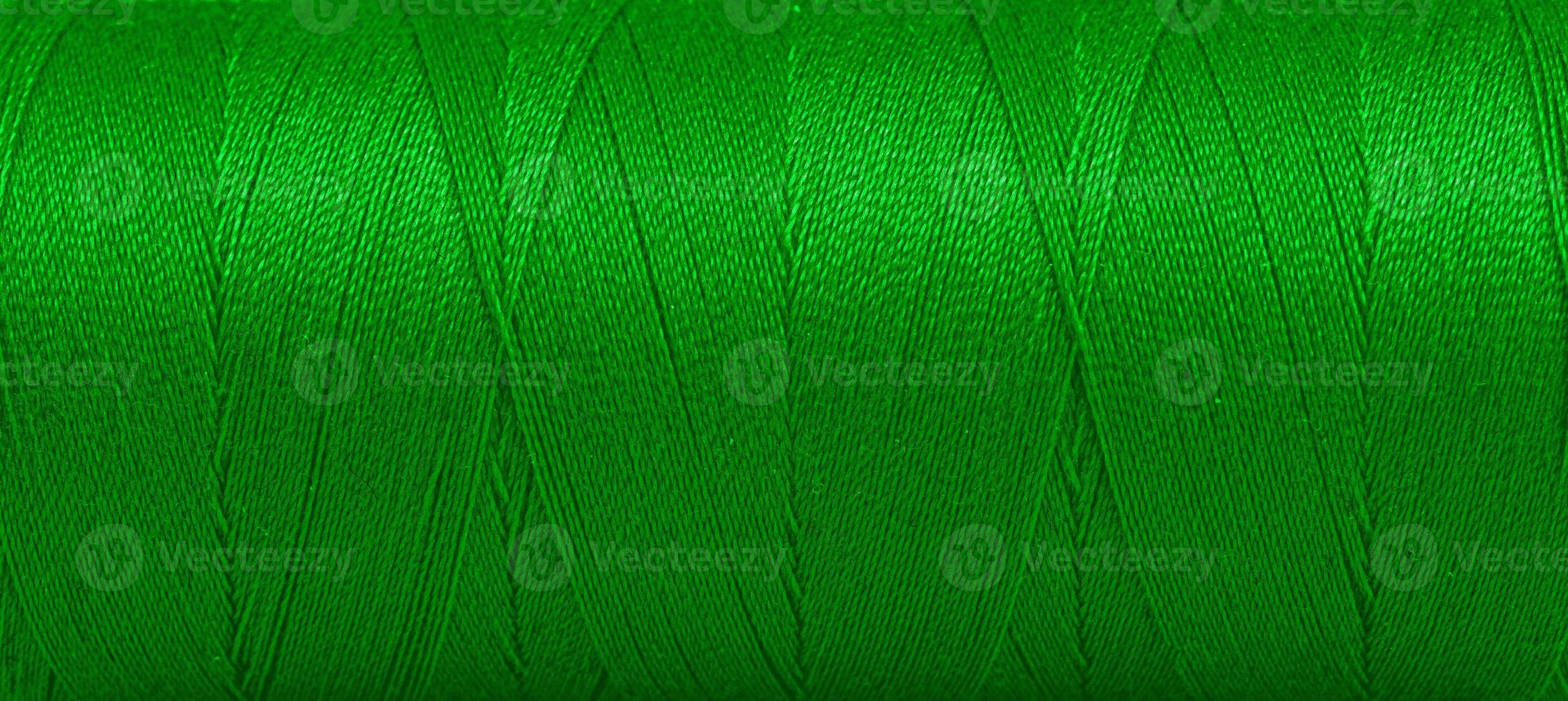 Texture of threads in a spool of green color on a white background photo